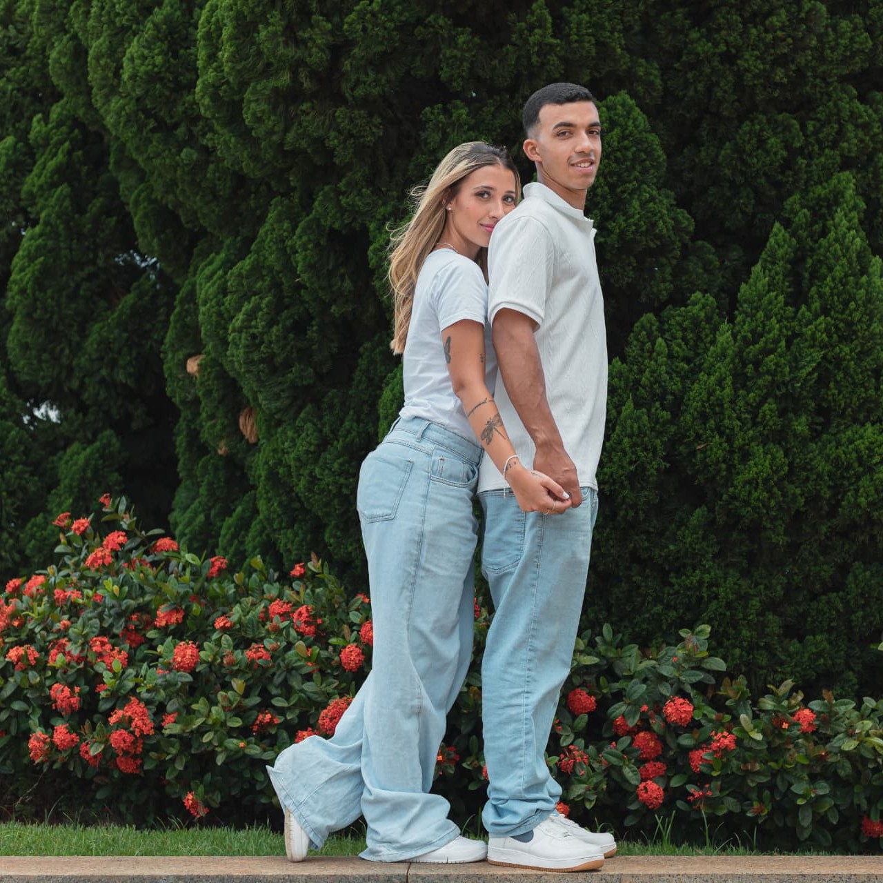 Alysson e Eduarda encostados de costas, de mãos dadas